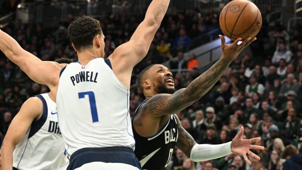 Milwaukee Bucks guard Damian Lillard (0) puts up a shot against Dallas Mavericks center Dwight Powell (7)